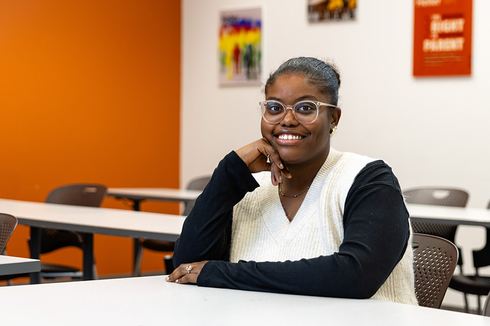 Quieraney Belvin sits at a desk in a classroom.
