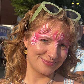 Cali McKenzie at a street fair, with pink butterfly face paint