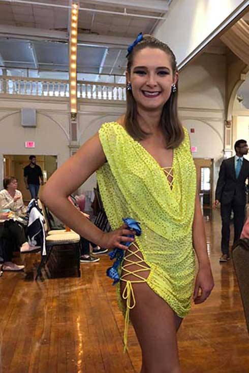Emily Calobrisi poses in a colorful ballroom dance costume.