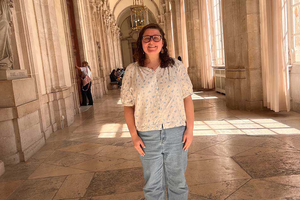 Emily Ziperman stands in an old-fashioned hallway.
