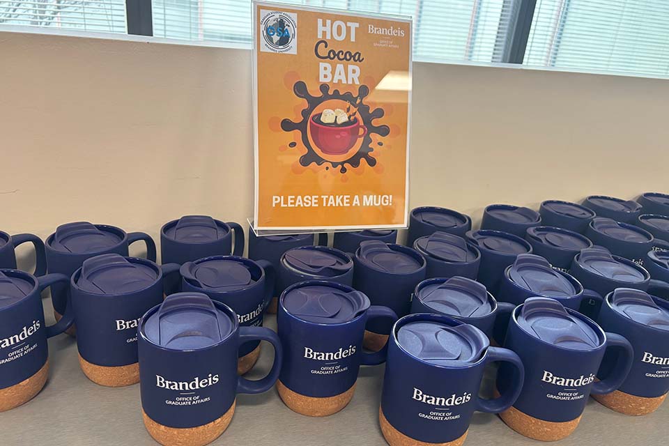 Office of Graduate Affairs branded mugs on a table