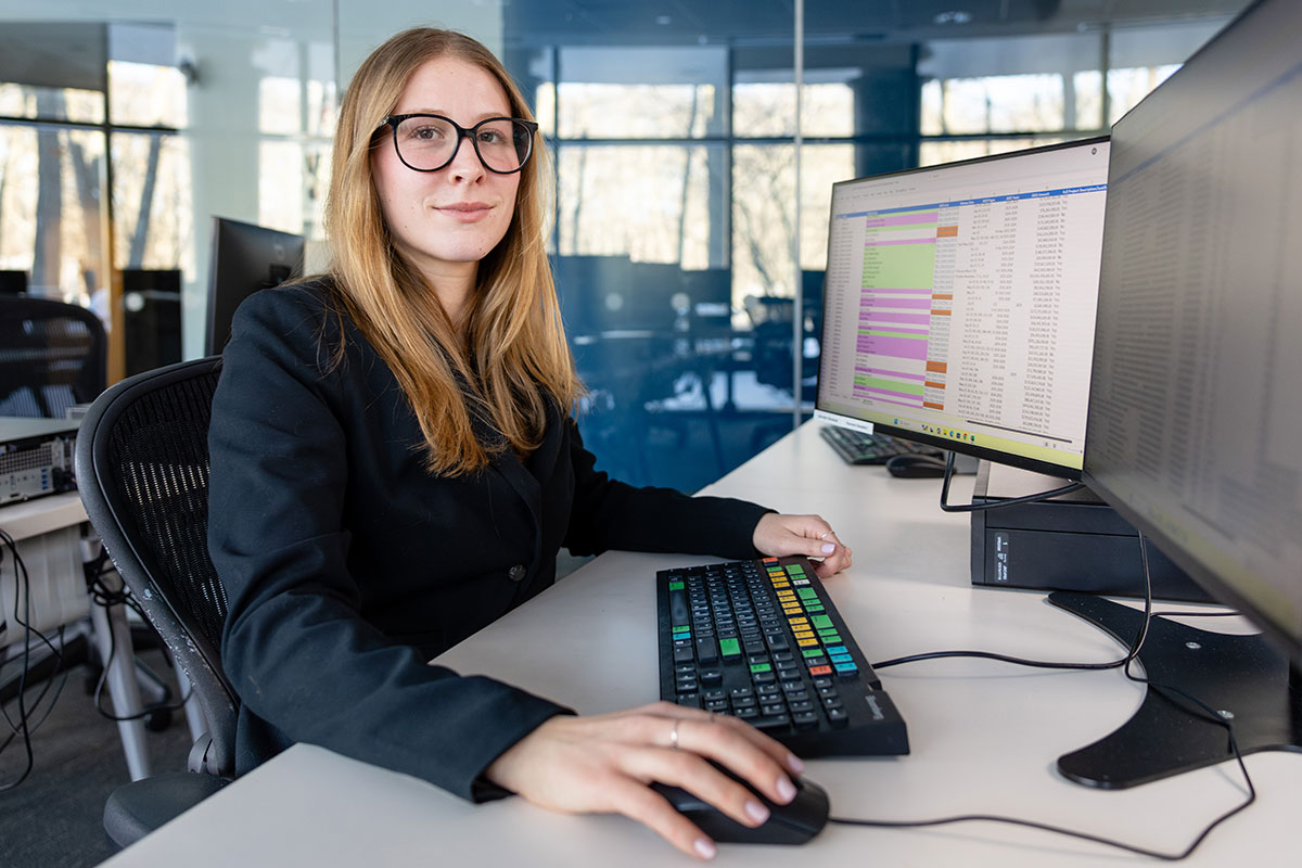 Hannah Guay sits at a computer with a spreadsheet onscreen.