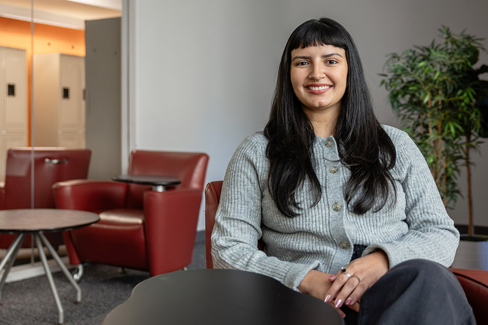 Chloe Morales sits in a chair with desk attachment.