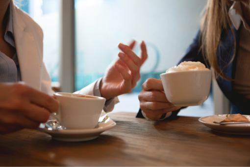 Two people talking with coffee cups