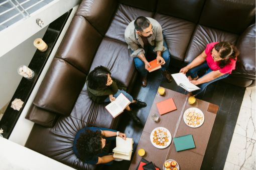 People sitting on couches holding books