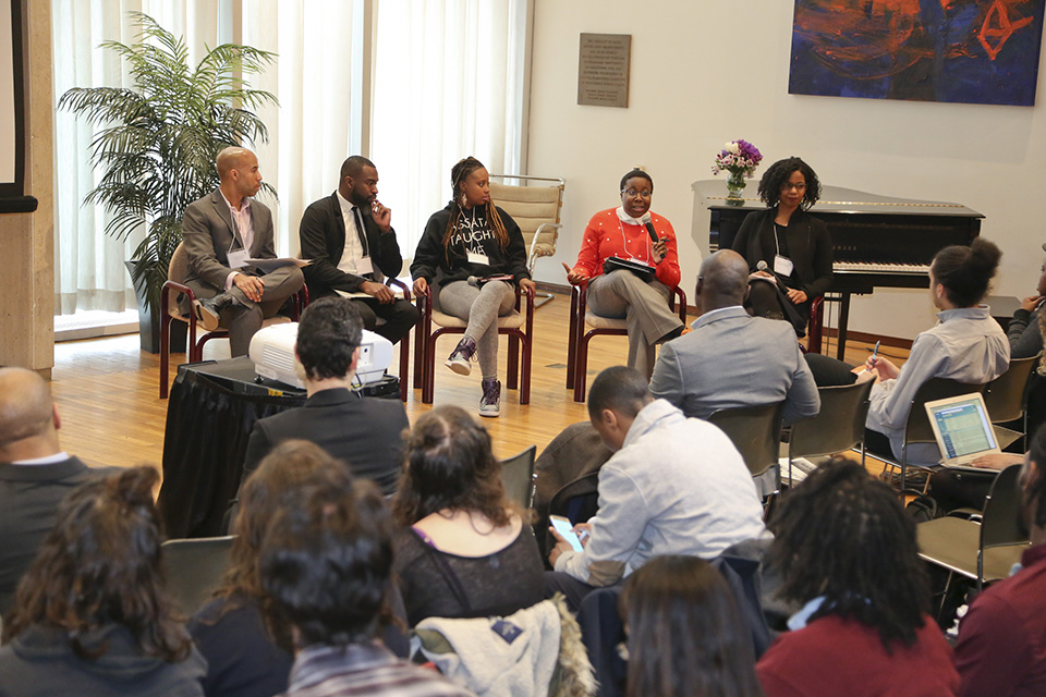conference panelists present in front of large audience
