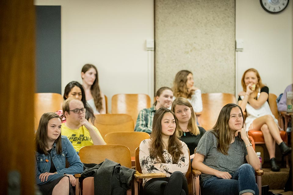 Several students seated in a classroom listening to a German lecture