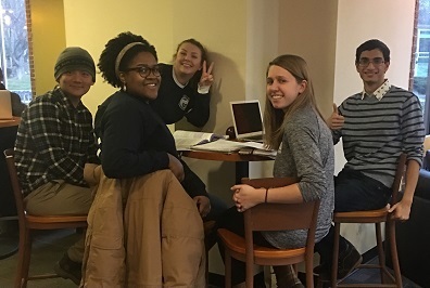 Group of students seated at a table smiling