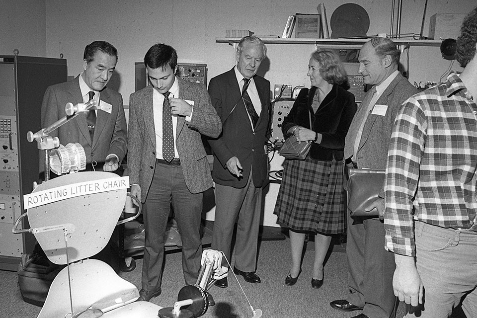 Black and white photo of people looking at scientific equipment