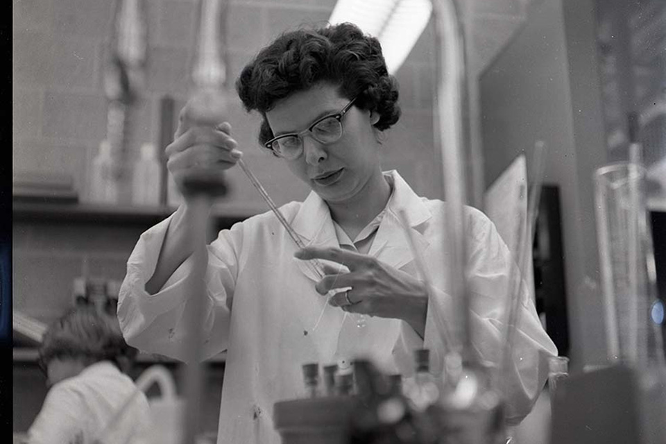 A woman works with a test tube in a lab.