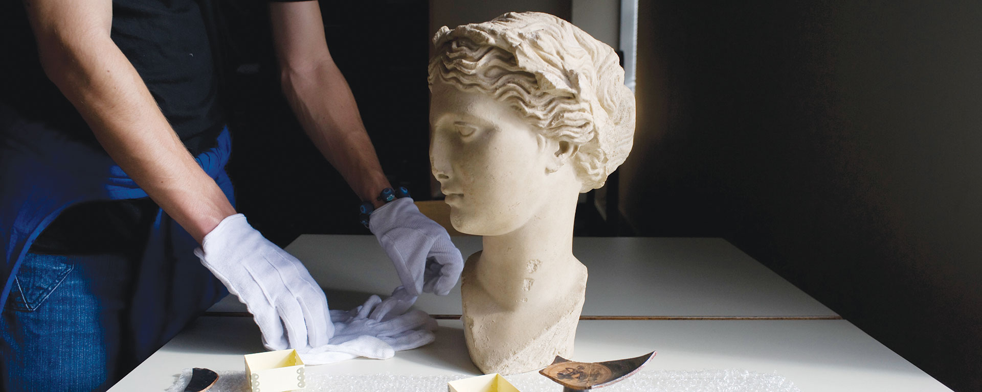 researcher analyzing the head of a statue