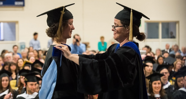 Professor Caren Irr hoods a doctoral student at a past Commencement celebration