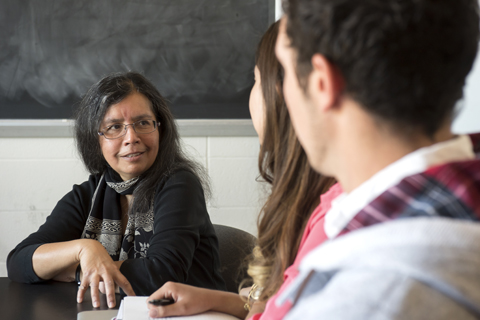 A faculty member speaking with students
