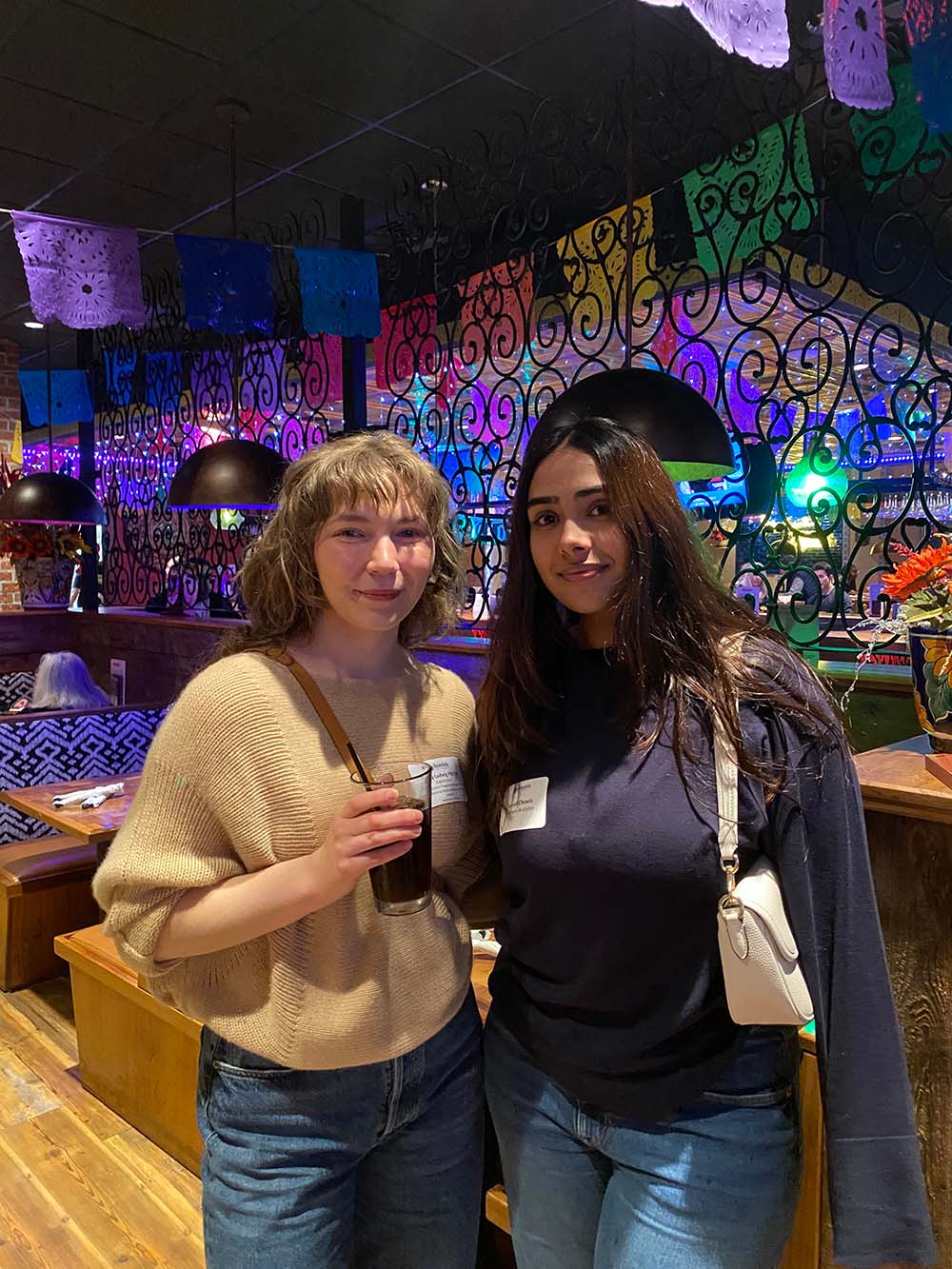 An alum and student stand together in Margaritas Mexican Restaurant.