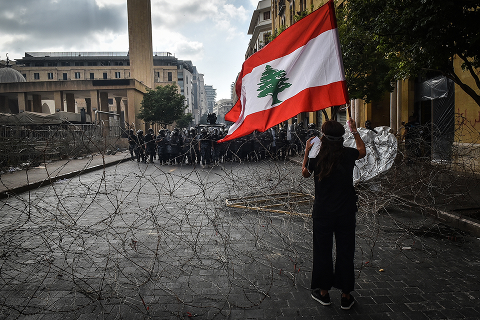 a protester faces police in beirut