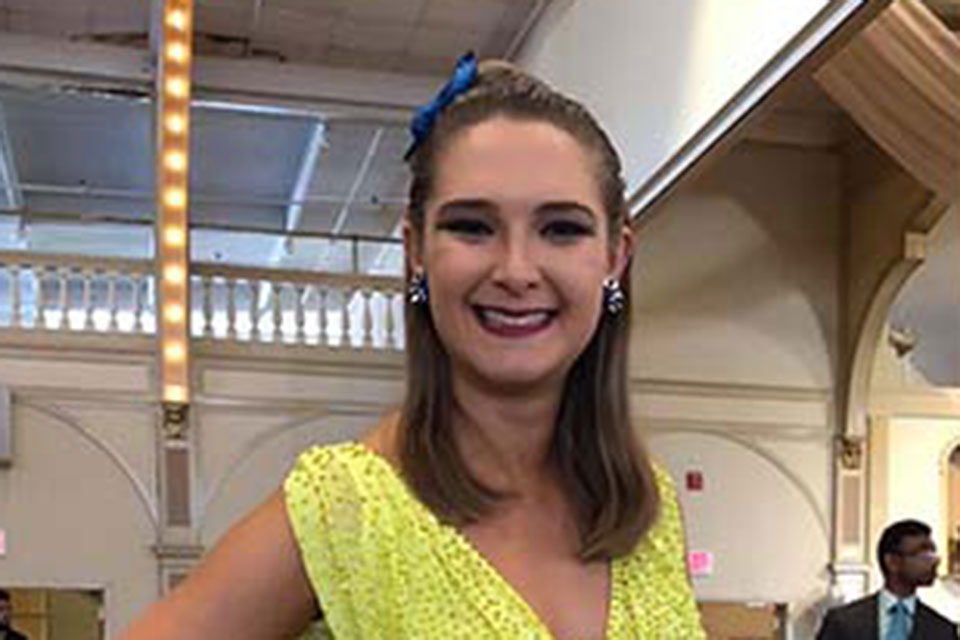 Emily Calobrisi poses in a colorful ballroom dance costume.
