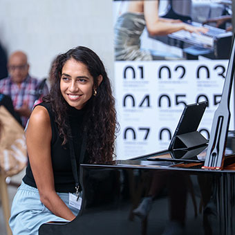 Mariel Mayz sits at a piano.