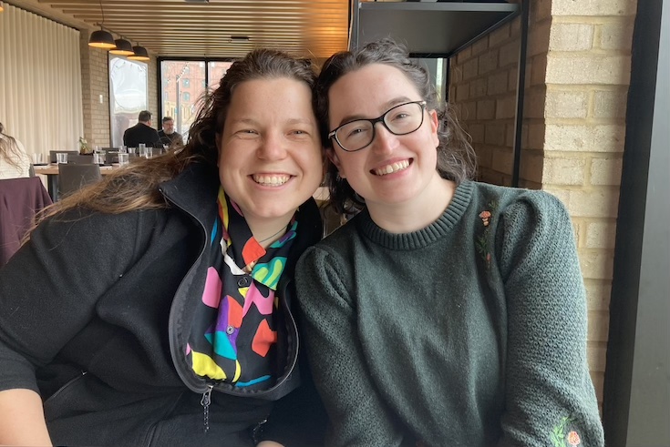 Graduate students Marie Comuzzo and Anna Valcour sit side by side.