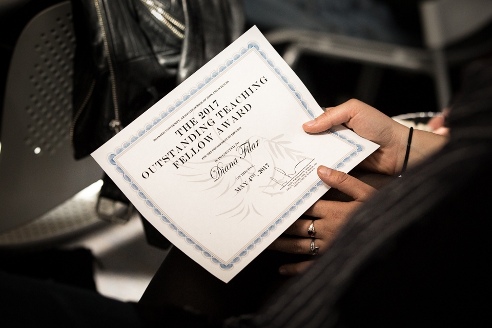 Hands hold a certificate reading, "The 2017 Outstanding Teaching Fellow Award."