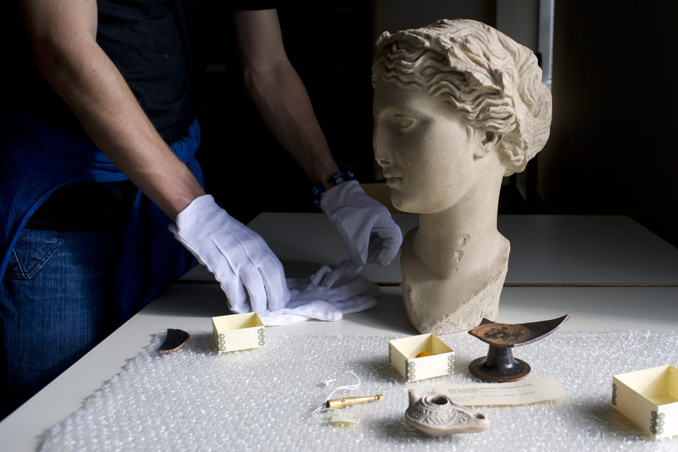 Person wearing gloves working on a bust