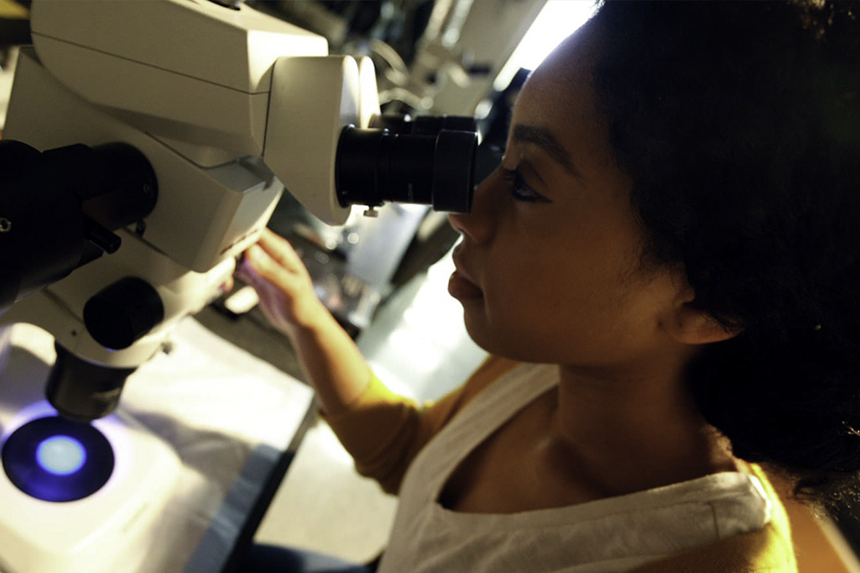 student using microscope