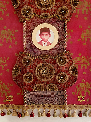small red and gold tapestry with an image of the boy in the center. the tapestry is embellished with cords and tassles. 