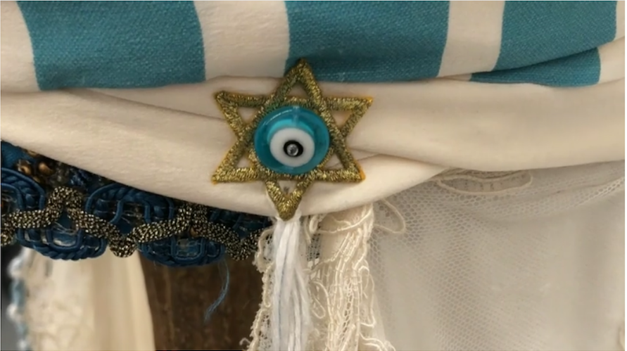 close up of turban-wrapped fez cap with blue decorative Star of David