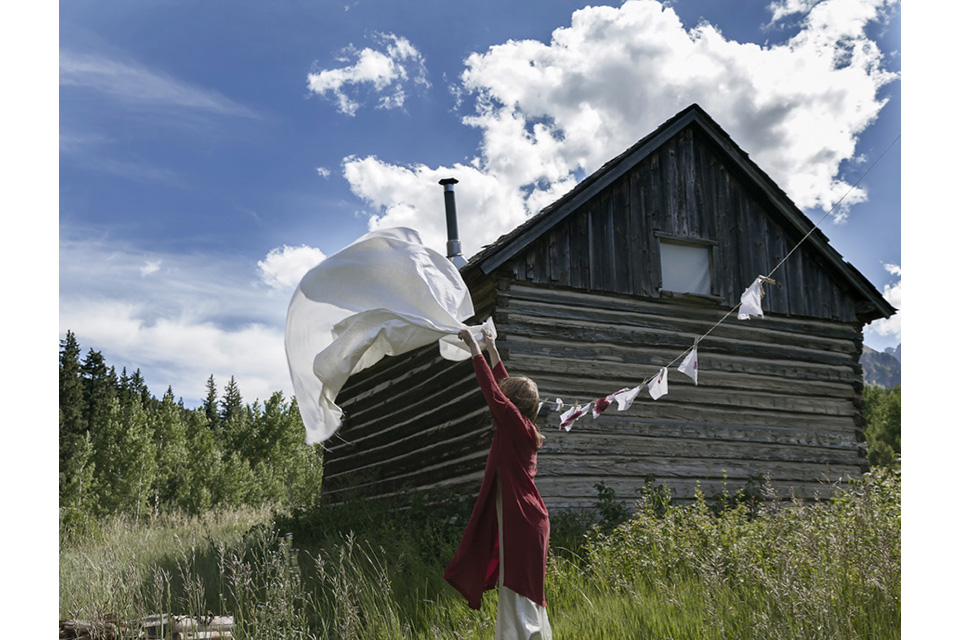 woman shaking white cloth out to dry