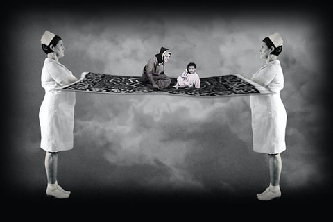 A black and white video still in which two identical nurses stand with crossed arms on either side of a mother and child sitting on a floating carpet.