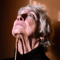 A women with a yad pointing up into her raised neck