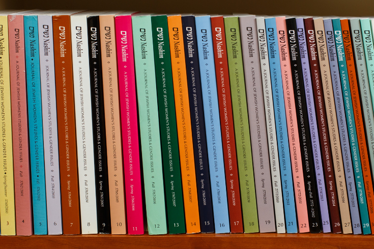 multiple nashim journals on a bookshelf