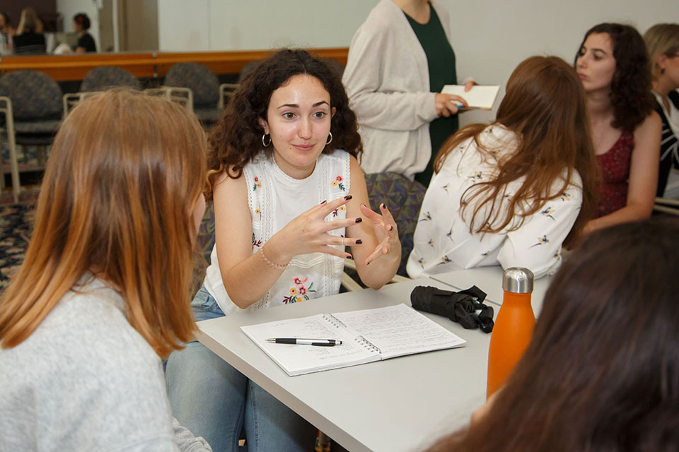 Students sit and talk at a table