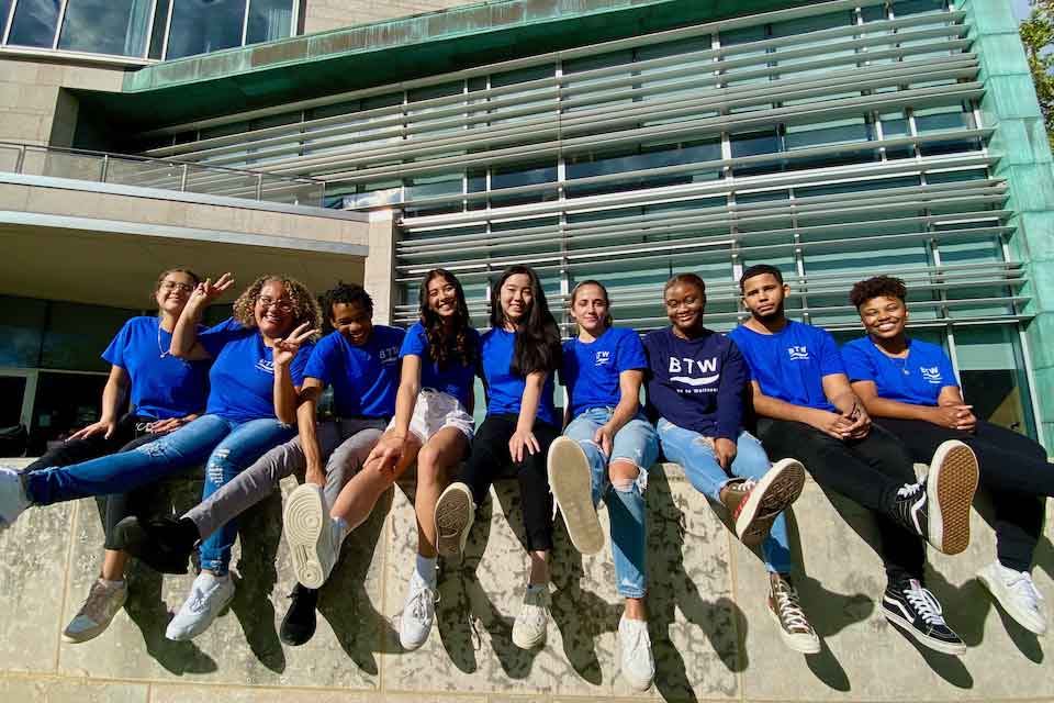 BTW peer educators sitting on a wall in front of the Shapiro Campus Center