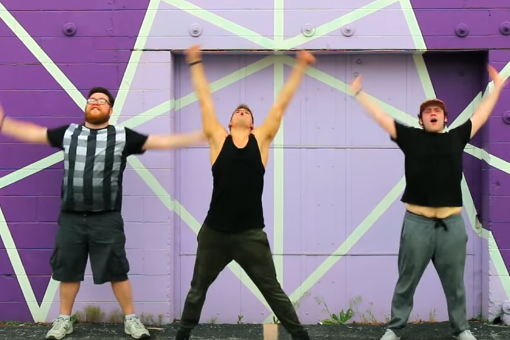 three men dancing in front of a purple wall