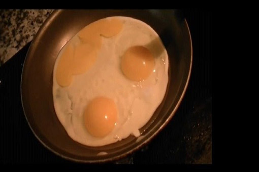 Eggs in a frying pan forming a smiley face