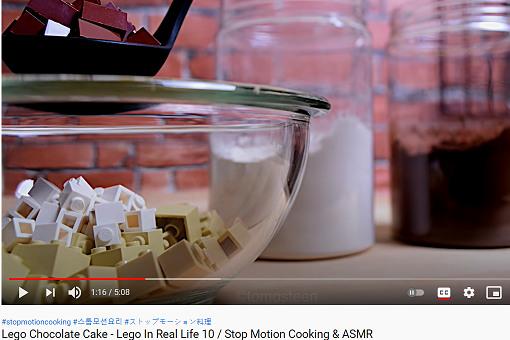 Screenshot of a bowl with lego pieces and a jars of flour and cocoa powder in the background. 