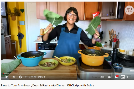 Chef Solha El-Waylly in her kitchen with many leafy greens.