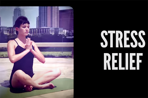 Image of Adriene (of Yoga with Adriene) sitting on a yoga mat in front of a city skyline