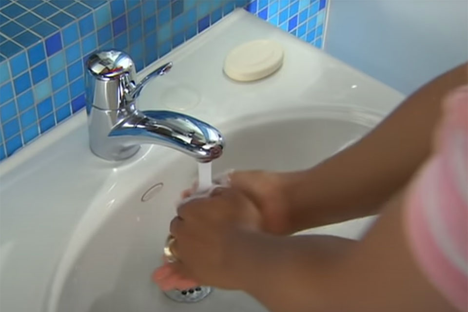 Person washing hands in a sink.