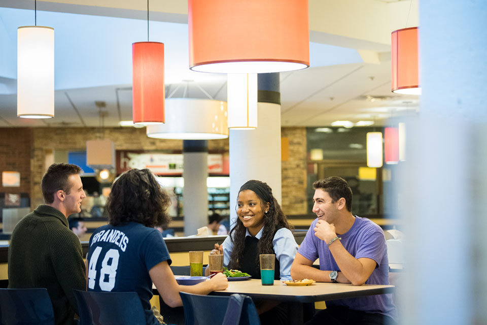 Students sit at a table in the dining hall