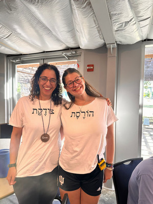 two counselors wearing shirts with Hebrew writing