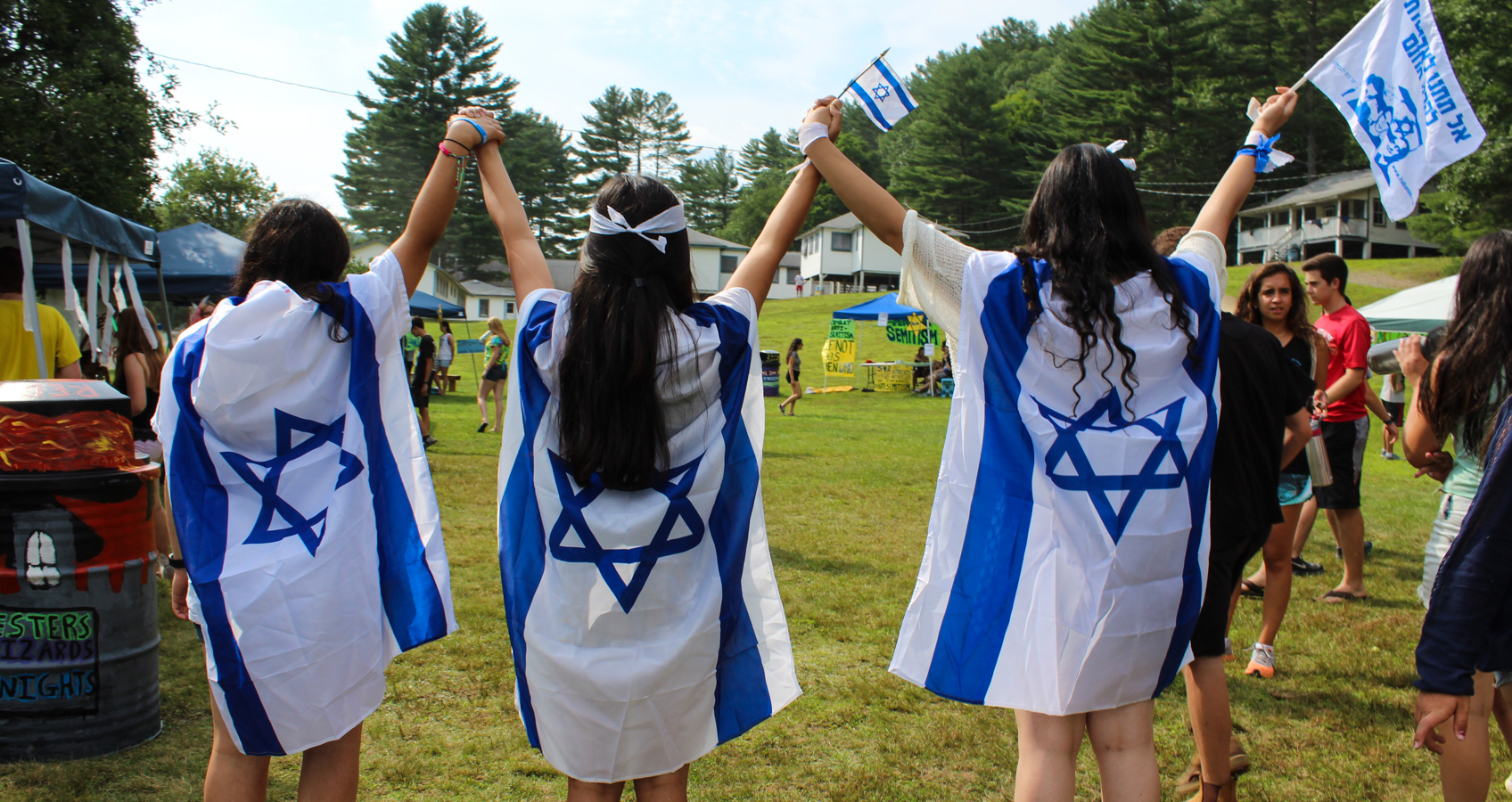 girls holding hands and wearing Israeli flags