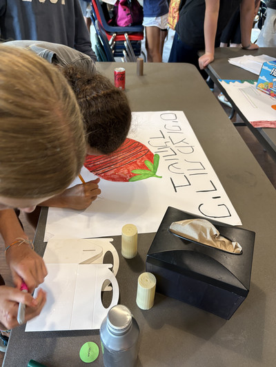 kids making a poster in hebrew
