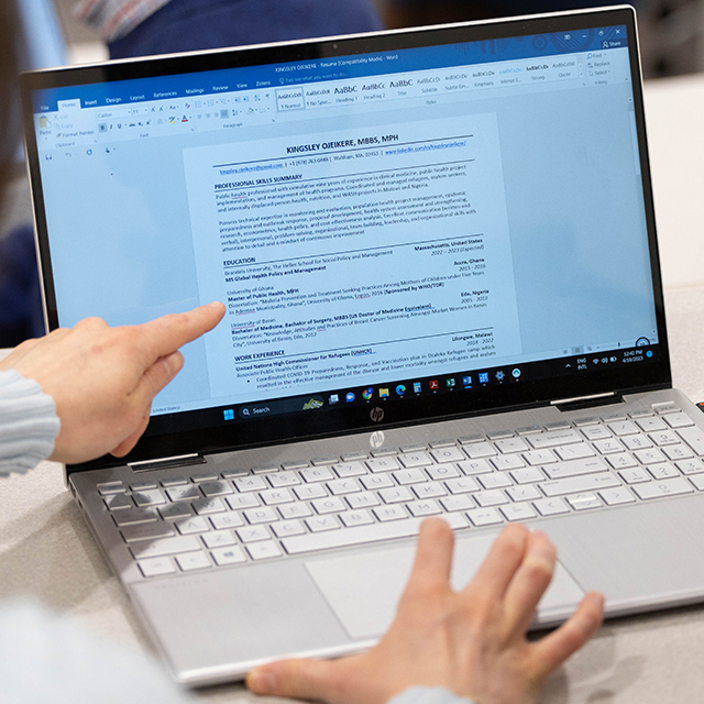 Students go over their resumes on a computer.