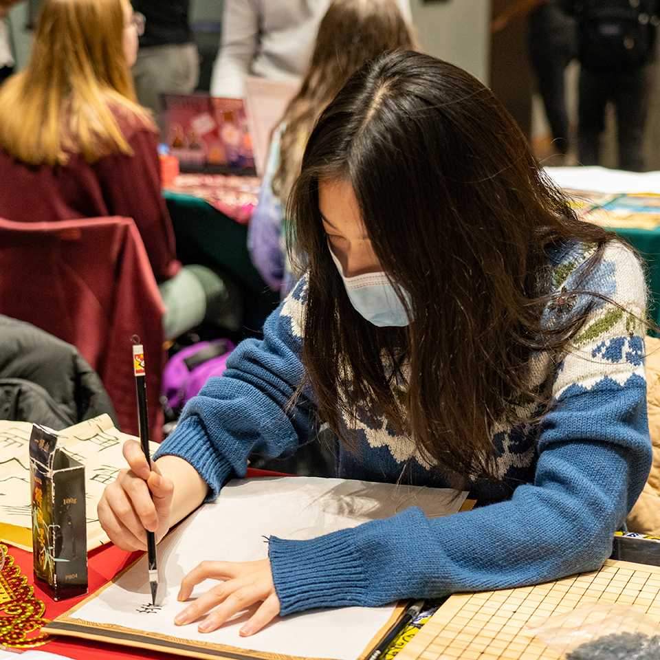 A student writes in their native language during the Fall 2022 Global Bazaar