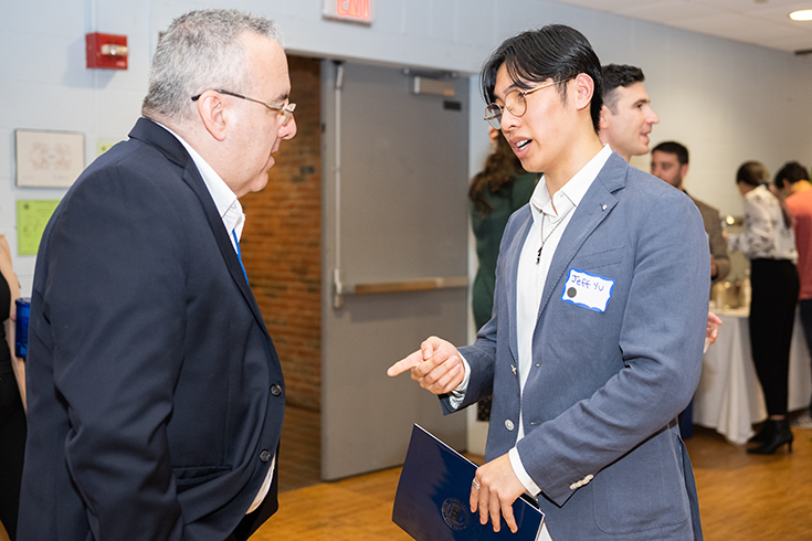 Jeff Yu ‘25 speaks with a Brandeis alumnus during Deis Dinner 2022.