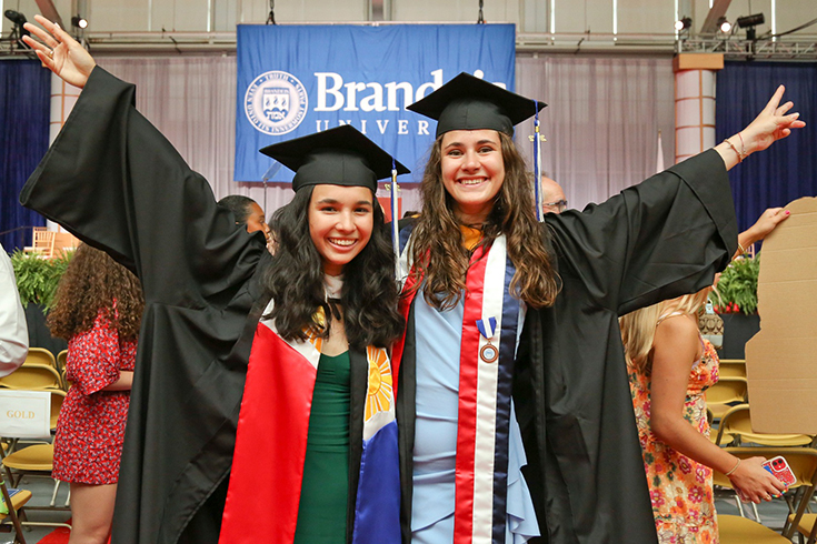 Two graduates from the Class of 2022 pose in their regalia during Brandeis’ 71st Commencement.