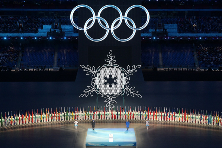 Cai Qi (left) and Thomas Bach (right) stand on a blue platform during the XXIV Winter Olympic Games in Beijing Opening Ceremony. Image courtesy of the President of the Russian Federation.