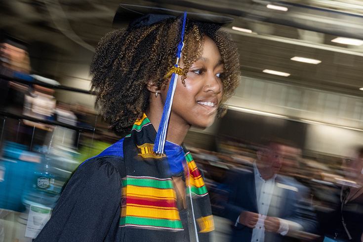 Brandeis University students walk across the stage during the undergraduate Commencement ceremony at the Gosman Sports and Convocation Center on May 21, 2023.