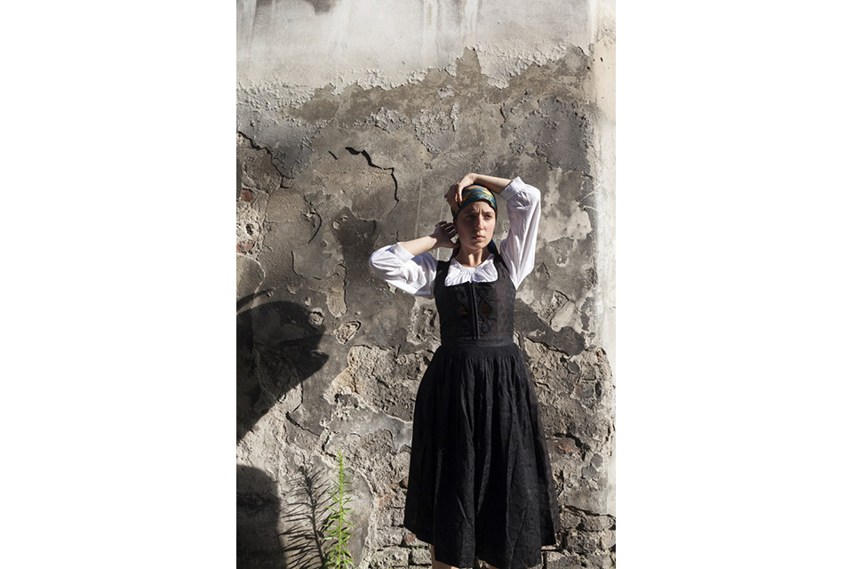 image of woman standing near stone wall